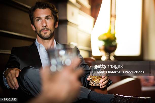 businessman with glass of whiskey in a bar - bar berlin stock pictures, royalty-free photos & images