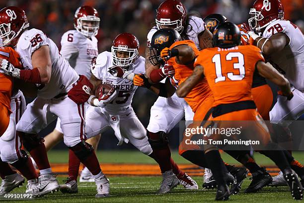 Running back Joe Mixon of the Oklahoma Sooners rushes against safety Jordan Sterns of the Oklahoma State Cowboys and linebacker Seth Jacobs of the...