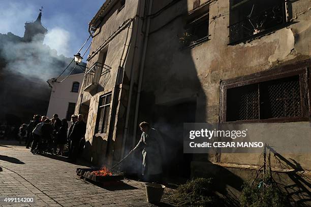 Woman lights a bonfire on November 29 in the northern Spanish village of Arnedillo prior to celebratring the "Procession of smoke". Locals light...