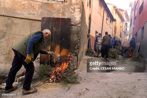 Man lights a bonfire on November 29 in the northern Spanish village of Arnedillo prior to celebratring the "Procession of smoke". Locals light...