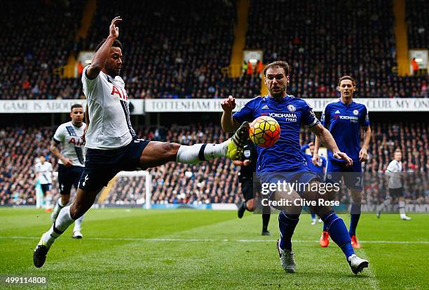 Mousa Dembele of Tottenham Hotspur stretches for the ball ahead of Branislav Ivanovic of Chelsea during the Barclays Premier League match between...