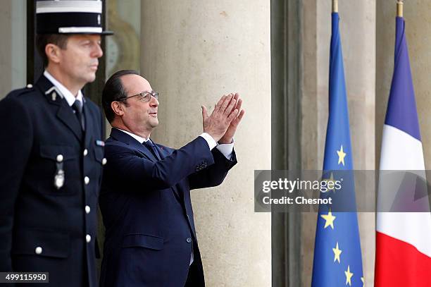 French President Francois Hollande gestures as United Nations Secretary-General Ban Ki-moon leaves the Elysee Presidential Palace on November 29,...