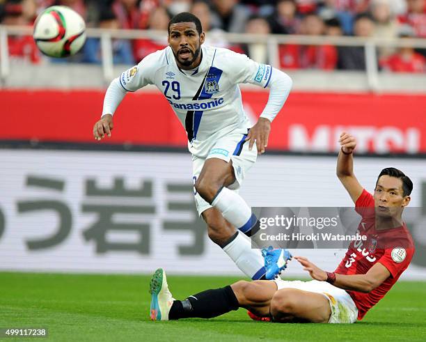 Patric of Gamba Osaka shoots at goal under pressure of Tomoaki Makino of Urawa Red Diamonds during the J.League 2015 Championship semi final match...