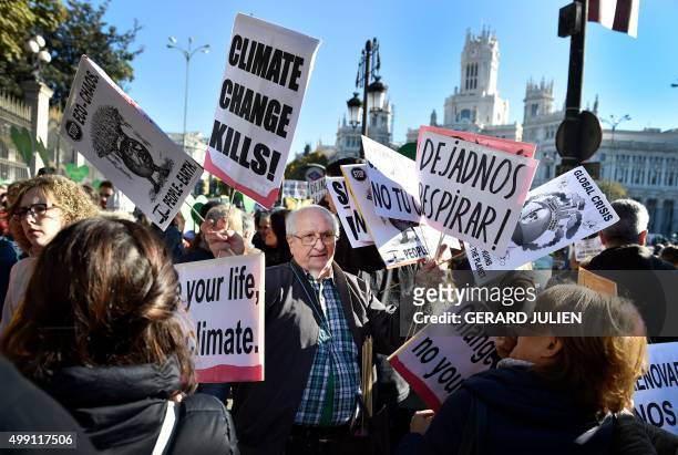 Man distributes placards against the climate change during the "Global Climate March" on November 29, 2015 in Madrid, called by environmental NGOs on...