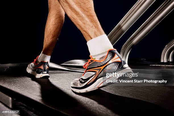 close up of male legs running on gym treadmill in altitude centre - 人体部位 ストックフォトと画像