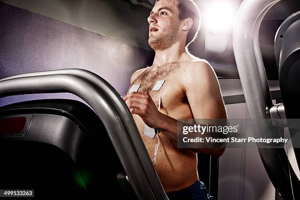 young man with heart rate monitor on gym treadmill in altitude centre - running man heartbeat stock pictures, royalty-free photos & images