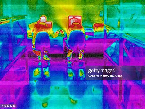 infra red heat image of workers and heat loss at computer work station - thermal image photos et images de collection