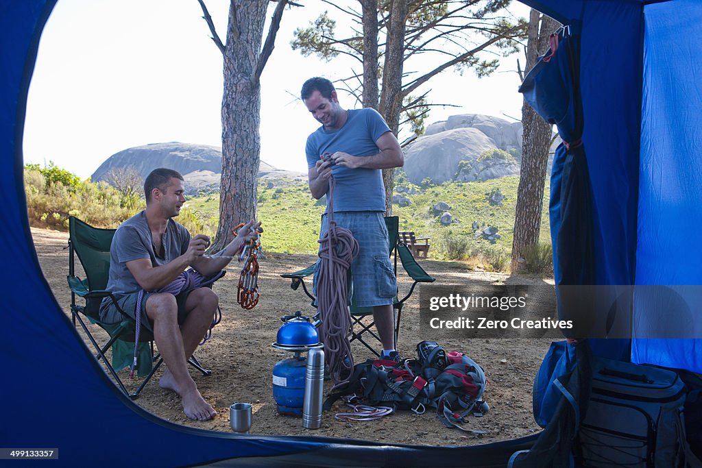 Two young men chatting and preparing camp