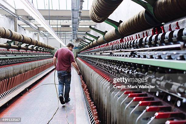male factory worker monitoring weaving machines in woollen mill - textile industry stock-fotos und bilder