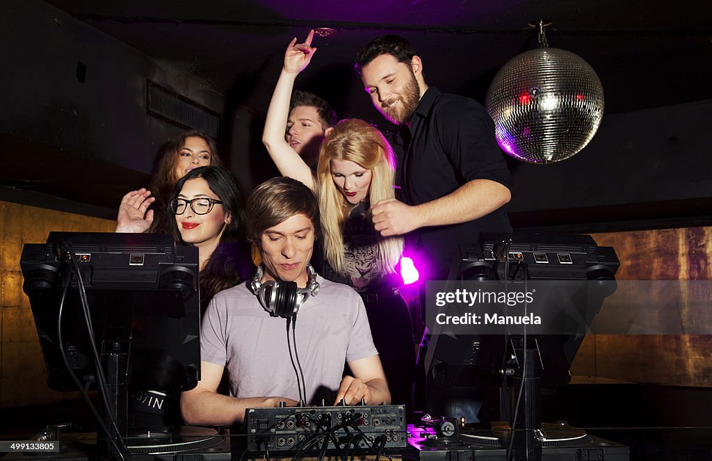 Group of friends watching DJ in nightclub