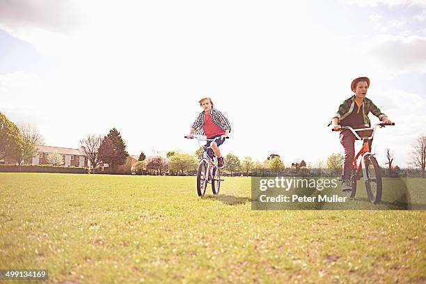 boys cycling on playing field - peter parks fotografías e imágenes de stock