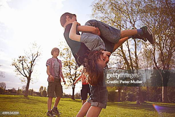 boys play fighting on playing field - rough housing stock-fotos und bilder