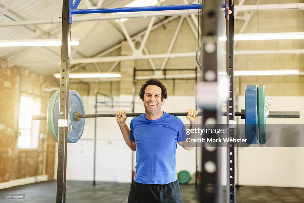 Man lifting barbell in gym