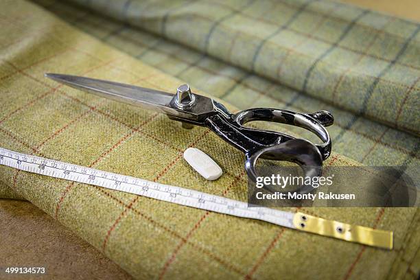 harris tweed material and scissors in clothing factory - ツイード　生地 ストックフォトと画像