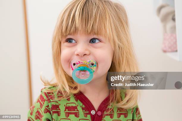 portrait of happy 2 year old girl with pacifier - pacifier stockfoto's en -beelden