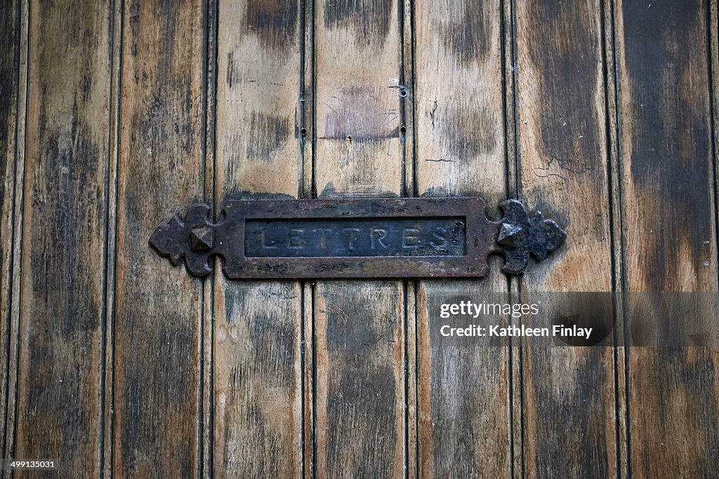 Detail of rustic letterbox and wooden door