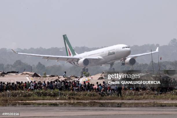 Internally displaced people from the Mpoko IDP's camp look at the Pope Francis' plane landing on November 29, 2015 in Bangui. Pope Francis arrived as...