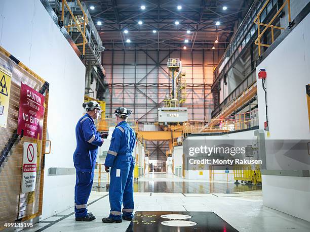 engineers in discussion in reactor hall in nuclear power station - centrale nucléaire photos et images de collection