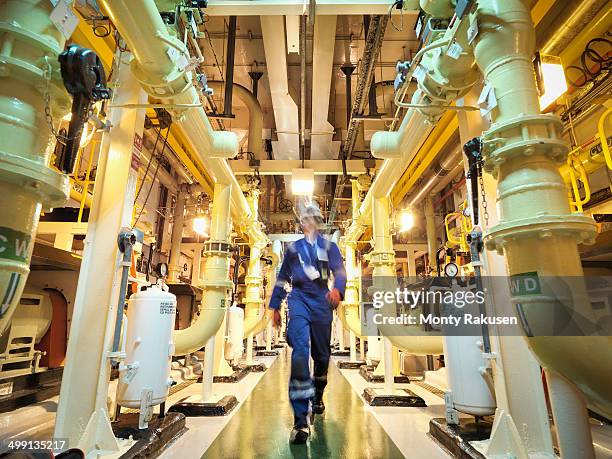 engineer walking amongst pipes of nuclear power station - nuclear power station stock pictures, royalty-free photos & images