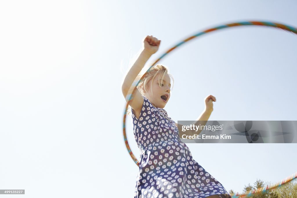 Low angle view of girl playing with plastic hoop
