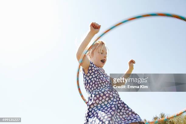 low angle view of girl playing with plastic hoop - drehen stock-fotos und bilder