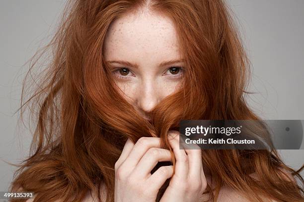 portrait of young woman, hands in hair - rote haare stock-fotos und bilder