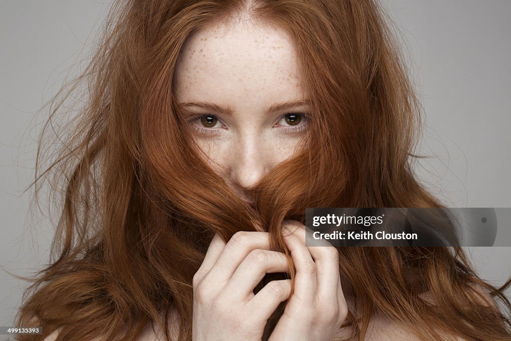 Portrait of young woman, hands in hair