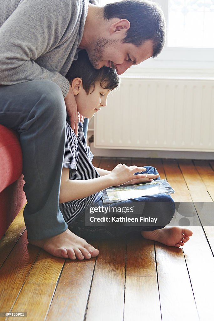 Father and son using digital tablet
