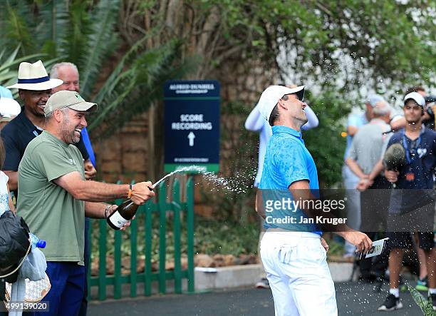 Charl Schwartzel of South Africa is sprayed with champagne by fellow countryman Hennie Otto as he leaves the green during the final round of the...