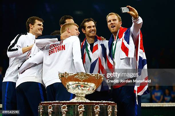 Dominic Inglot of Great Britain takes a selfie of his team-mates with the trophy following their victory during day three of the Davis Cup Final...