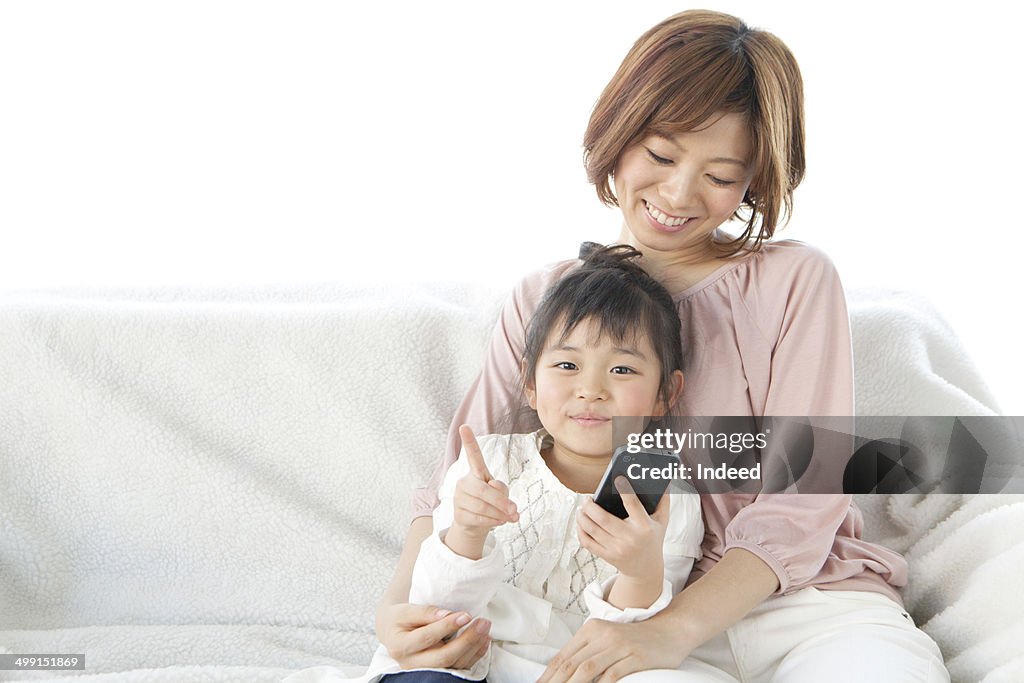 20th generation mother and 5-9 year old daughter who sit on a sofa