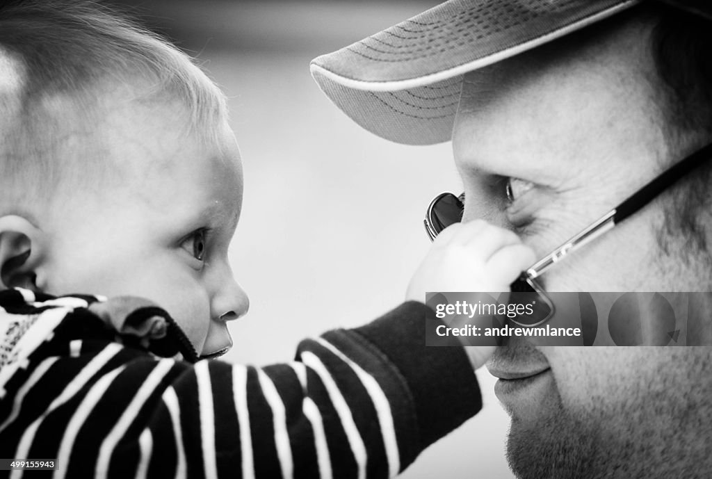 Baby boy playing with his father's sunglasses