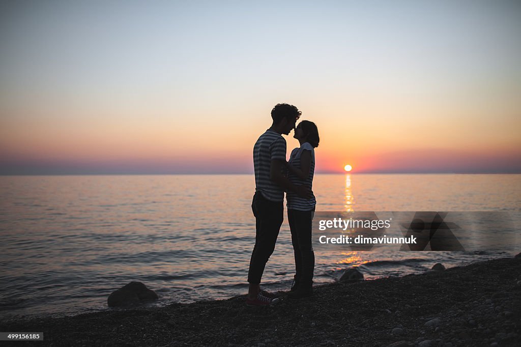 Teenagers (14-15) hugging each other at sunset