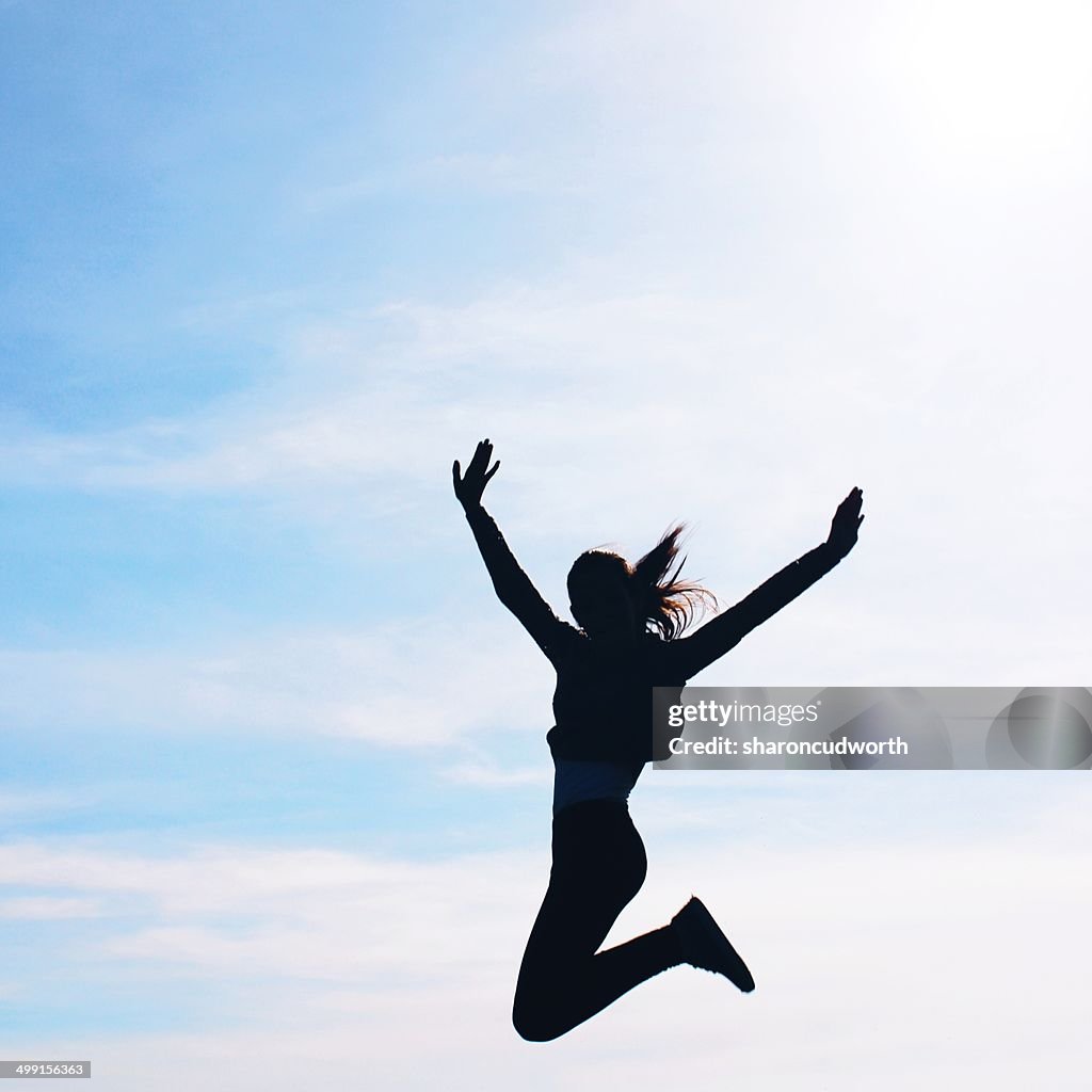 Silhouette of a girl jumping mid air