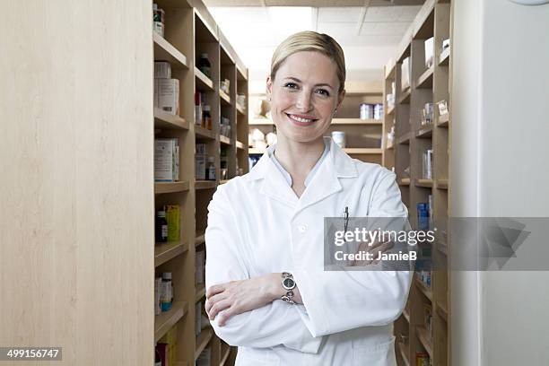 female pharmacist standing in pharmacy - apothekerin stock-fotos und bilder