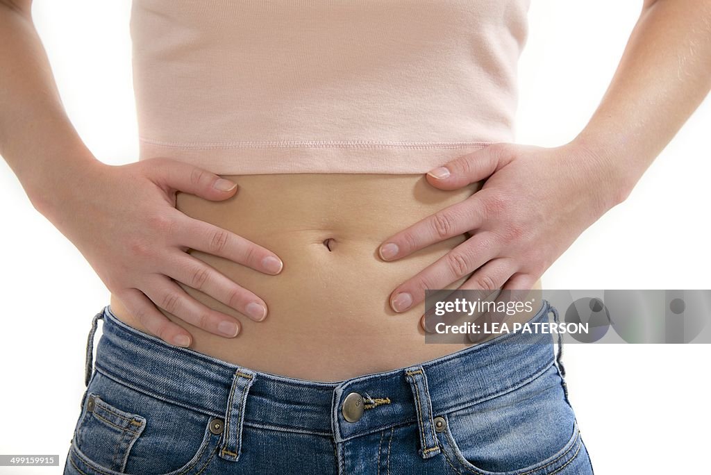 Teenage girl touching stomach