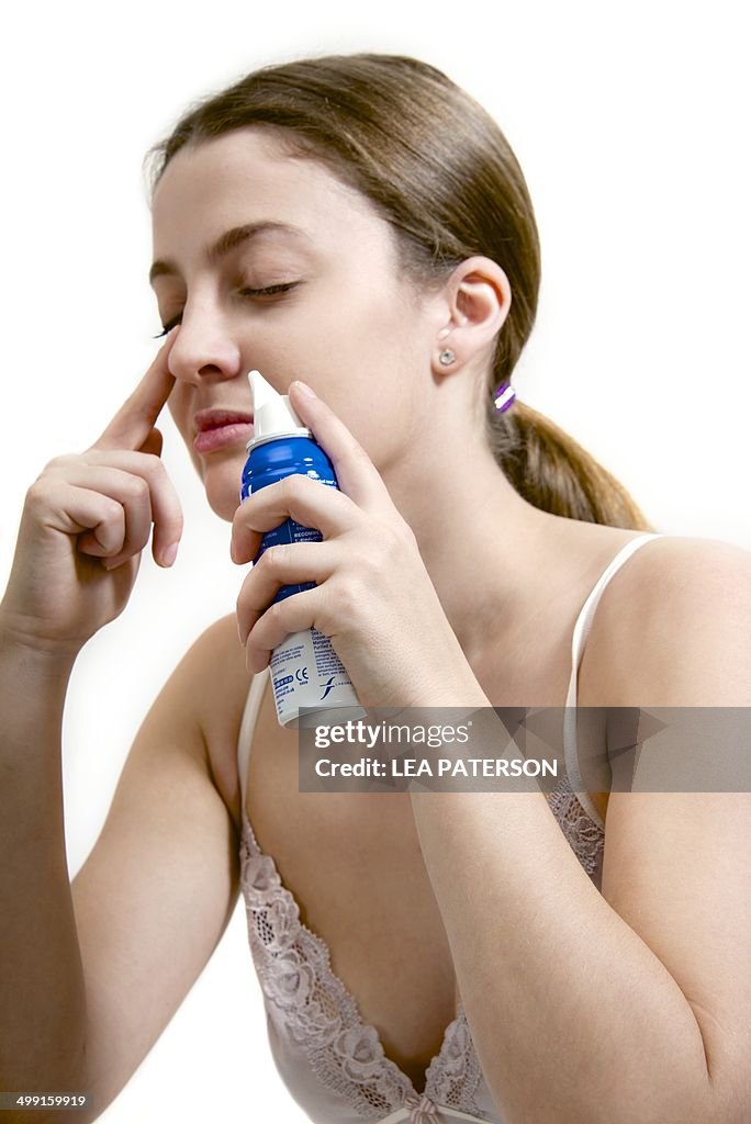 Teenage girl using decongestant