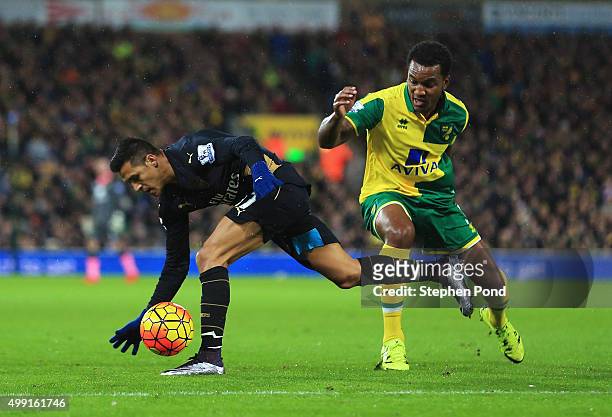 Alexis Sanchez of Arsenal evades Andre Wisdom of Norwich City during the Barclays Premier League match between Norwich City and Arsenal at Carrow...