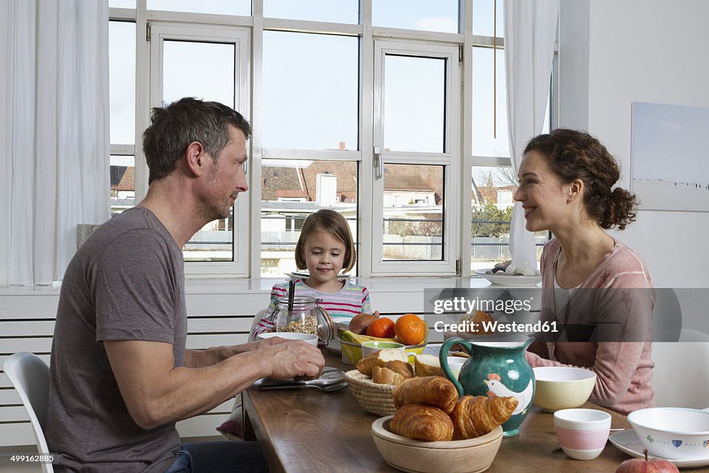 Father, mother and daughter having healthy breakfast