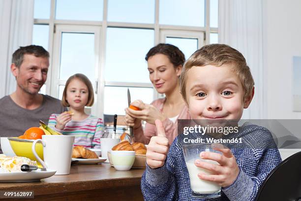 family of four having healthy breakfast - milk family stock pictures, royalty-free photos & images