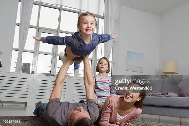 playful family in living room - 飛行機のまね ストックフォトと画像