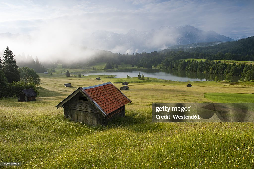 Germany, Bavaria, Werdenfelser Land, lake Geroldsee with hay barn at sunset, in background the Karwendel mountains