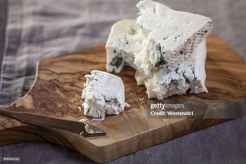 Pieces of gorgonzola cheese on chopping board