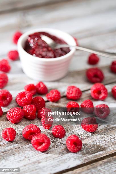 bowl of raspberry jam, spoon and raspberries on wooden table - raspberry jam stock pictures, royalty-free photos & images