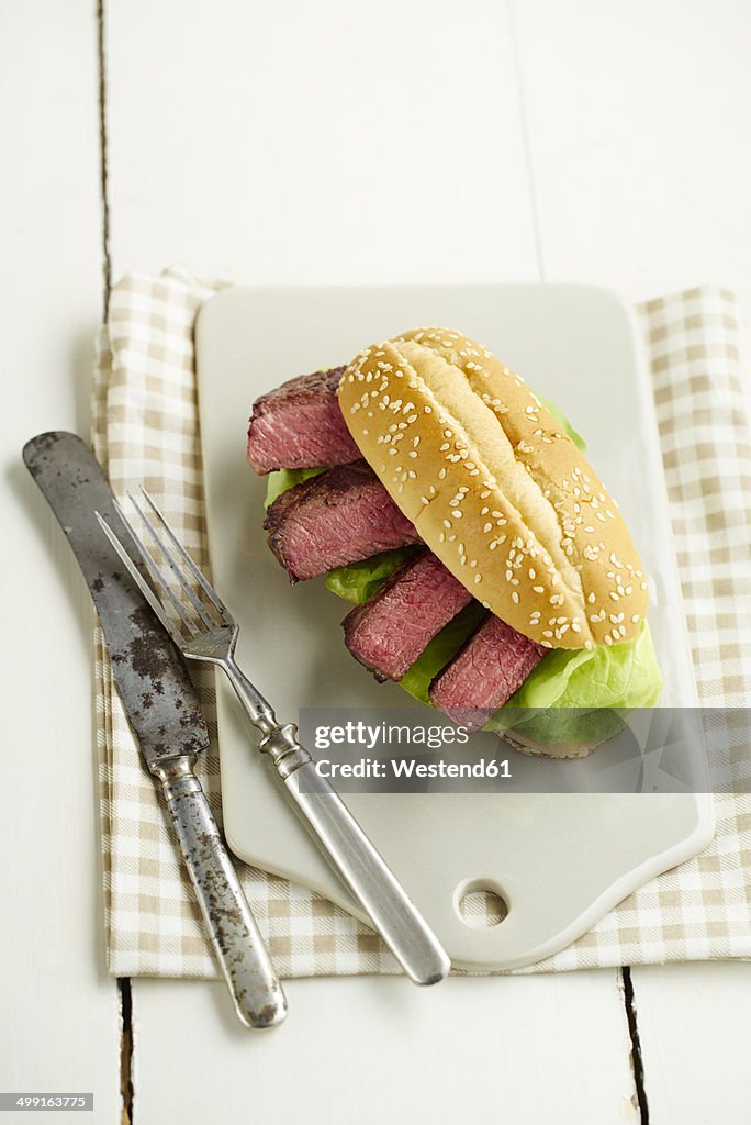 Steak-Burger with beefsteak and salad on chopping board