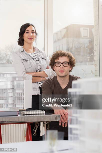 portrait of two young architects with architectural model in office - architekturmodell stock-fotos und bilder