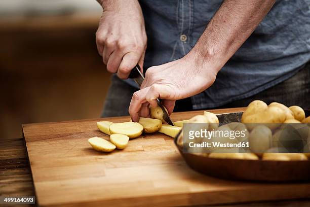 man cutting potatoes in kitchen - rå potatis bildbanksfoton och bilder