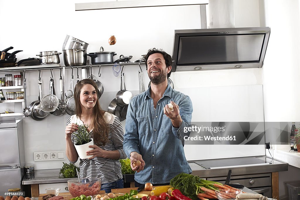 Man juggling with food in kitchen