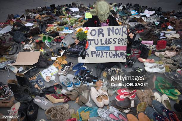 Man dressed as Yoda stands among shoes on the Place de la Republique which is covered in pairs of shoes on November 29, 2015 in downtown Paris, as...