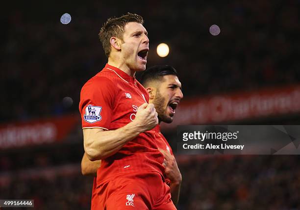 James Milner of Liverpool celebrates with Emre Can as he scores their first goal from a penalty during the Barclays Premier League match between...